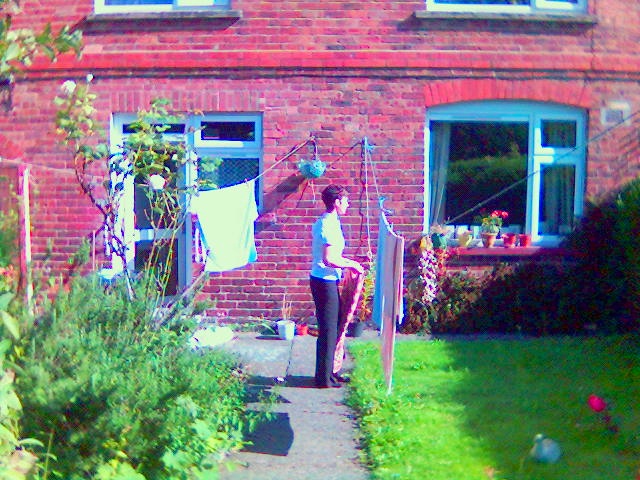 Photo angle of Mum hanging washing out in garden